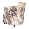 fauteuil PERLE tapissé d'un tissu motif rose, bleu et noir.