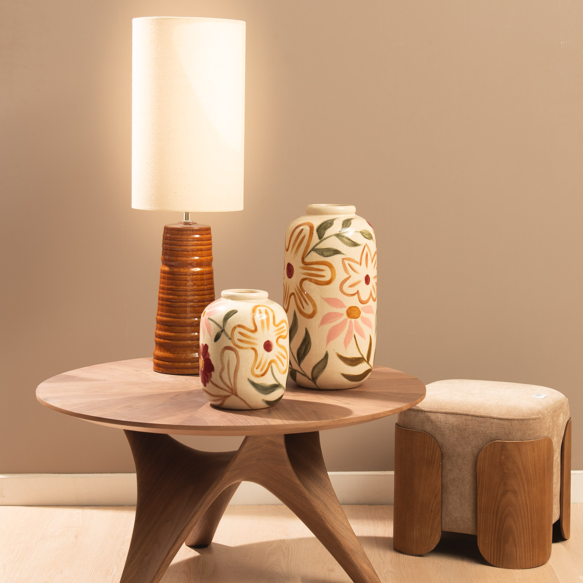 Ambiance de la table basse en noyer avec piètement central structural, diamètre 80cm